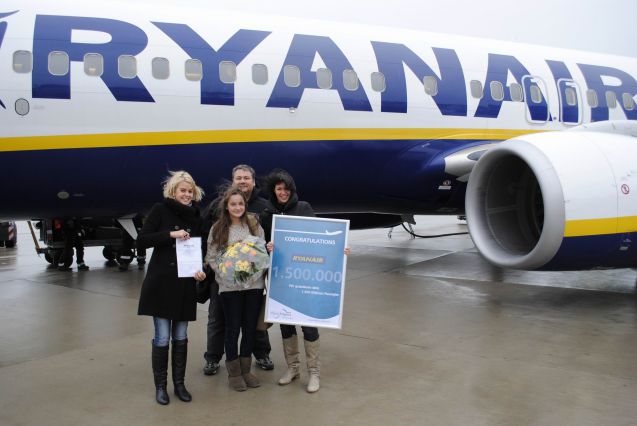 Jubiläums-Fluggast Carina Dünser mit Vater Philipp. Ryanair-Managerin Jana Skornicka (links) und Airport-Marketingleiterin Marina Siladji gratulierten mit Blumen und einem Fluggutschein; Bild: Allgäu Airport Memmingen