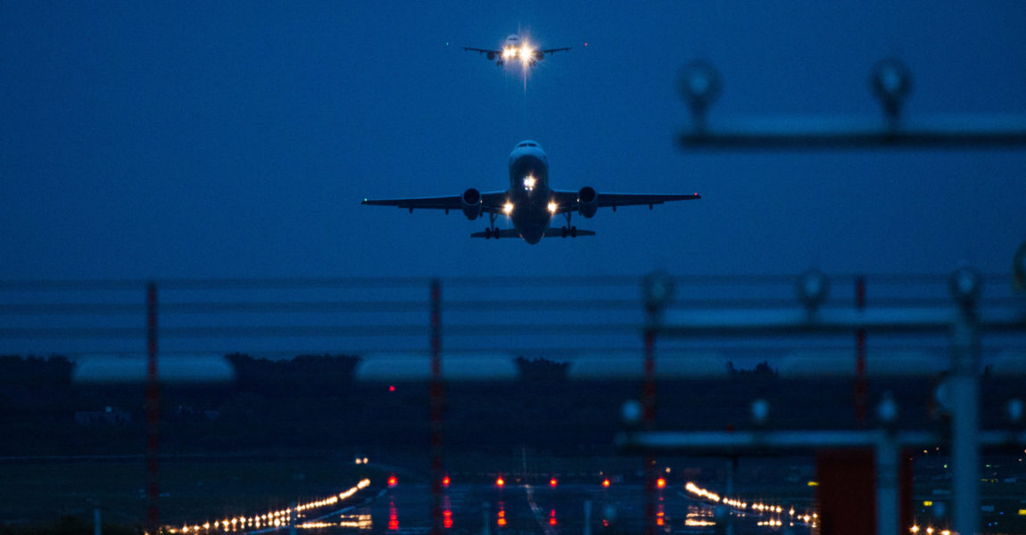 Ein Airbus A319-132 startet vom dem Flughafen in Hamburg. Im Hintergrund ist ein Flugzeug im Landeanflug. 