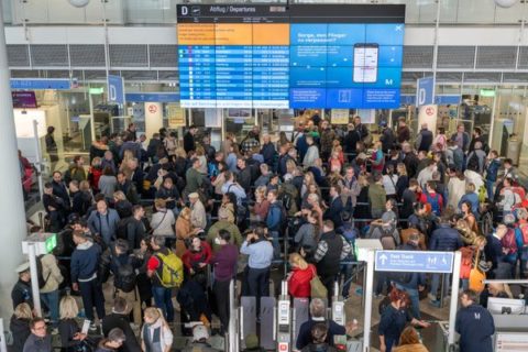 Passagiere stehen in der Abflughalle in Schlangen an, um zur Sicherheitskontrolle zu gelangen. 