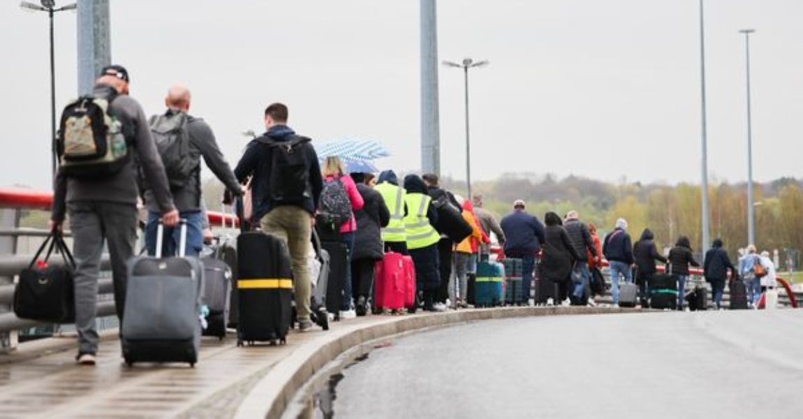 Flugreisende mit dem Ziel Antalya in der Türkei gehen vom Terminal 1 im Flughafen Hamburg zu einem wartenden Reisebus, der sie dann zum Flughafen nach Bremen bringt.