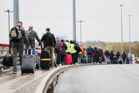 Flugreisende mit dem Ziel Antalya in der Türkei gehen vom Terminal 1 im Flughafen Hamburg zu einem wartenden Reisebus, der sie dann zum Flughafen nach Bremen bringt.