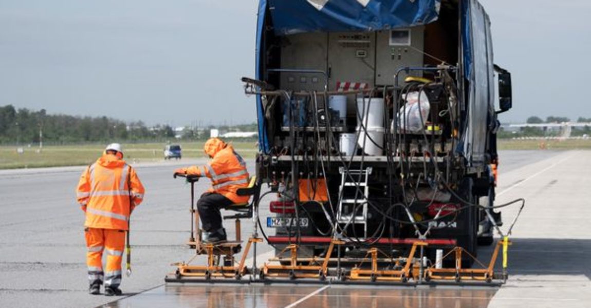 Eine spezielle Flüssig-Grundierung bringen Arbeiter mit einem Spezialfahrzeug auf der Landebahn Nordwest auf dem Flughafen in Frankfurt an.