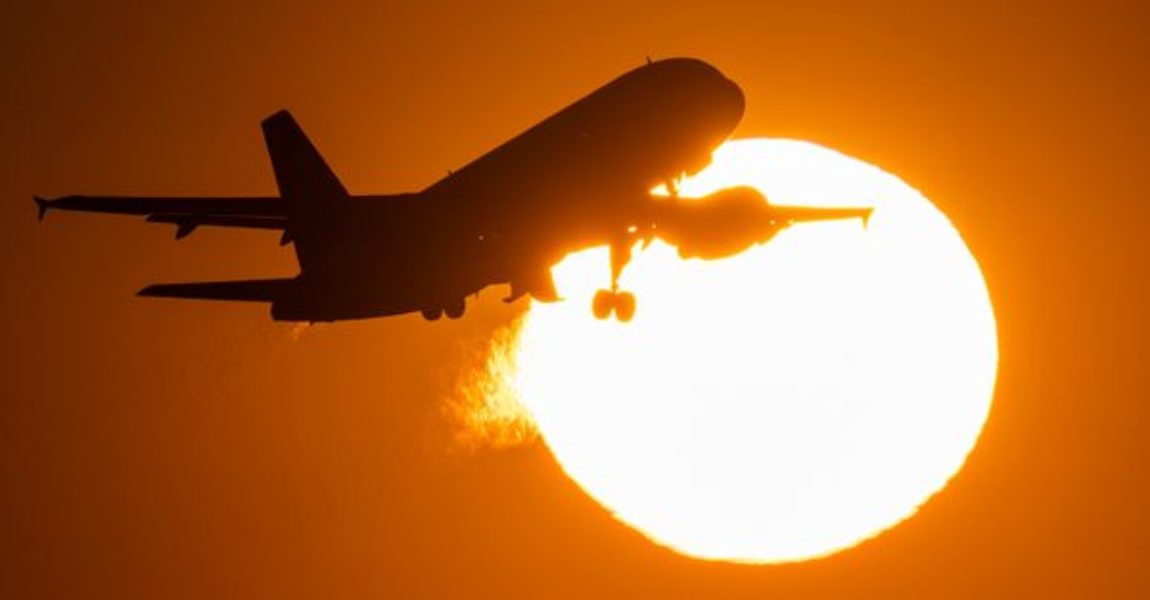 Eine Passagiermaschine hebt vor der untergehenden Sonne vom Flughafen Frankfurt ab.