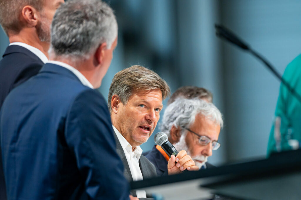 Robert Habeck (Bündnis 90/Die Grünen, M), Bundeswirtschaftsminister und Vizekanzler, spricht während der Konferenz auf dem Podium.