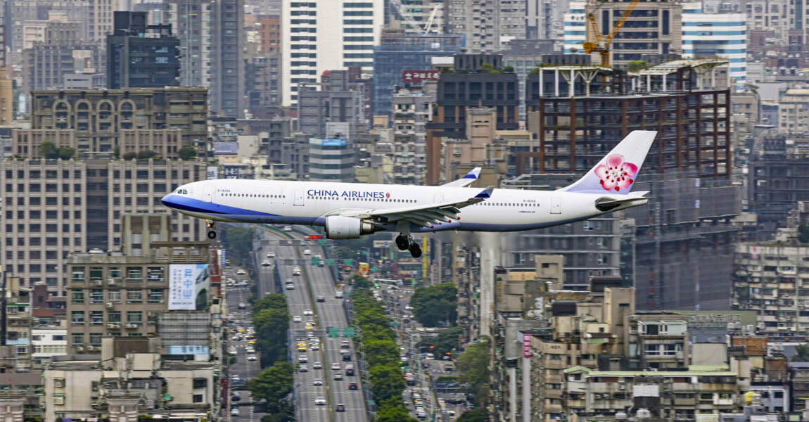 Zuweilen finden sich selbst Flugzeuge im Großstadt-Dschungel zurecht. Wie zum Beweis nimmt diese A330-300 der China Airlines, Kennung B-18356, problemlos Kurs auf ihren Heimatflughafen Taipeh. Und der italienische Fotograf Stefano Rizzi hielt den Anflug dankbar fest.