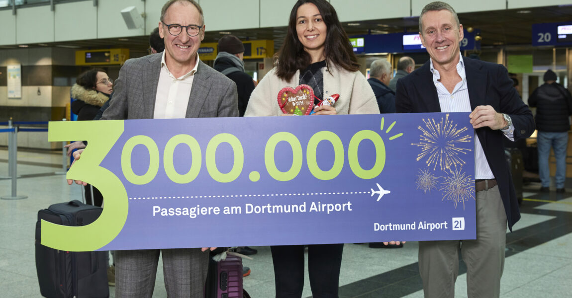 Ludger van Bebber, die Drei-Millionste Passagierin und Guido Miletic freuen sich über den neuen Rekord am Flughafen Dortmund.