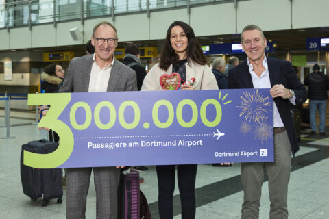 Ludger van Bebber,  die Drei-Millionste Passagierin und Guido Miletic freuen sich über den neuen Rekord am Flughafen Dortmund.