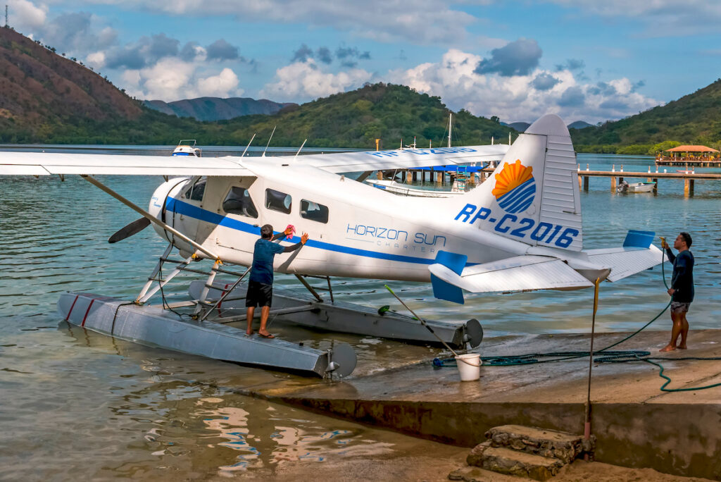 Salzwasser wird an stehendem Wasserflugzeug am Strand abgespült