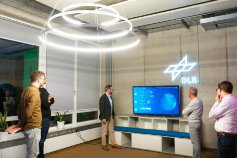 Der Luftfahrt-Presse-Club zu Gast im DLR-Institut für Luftverkehr. Im Bild zusammen mit Institutsdirektor Dr. Florian Linke (Mitte) vor einem Monitor, der die aktuellen globalen Flugbewegungen zeigt. 